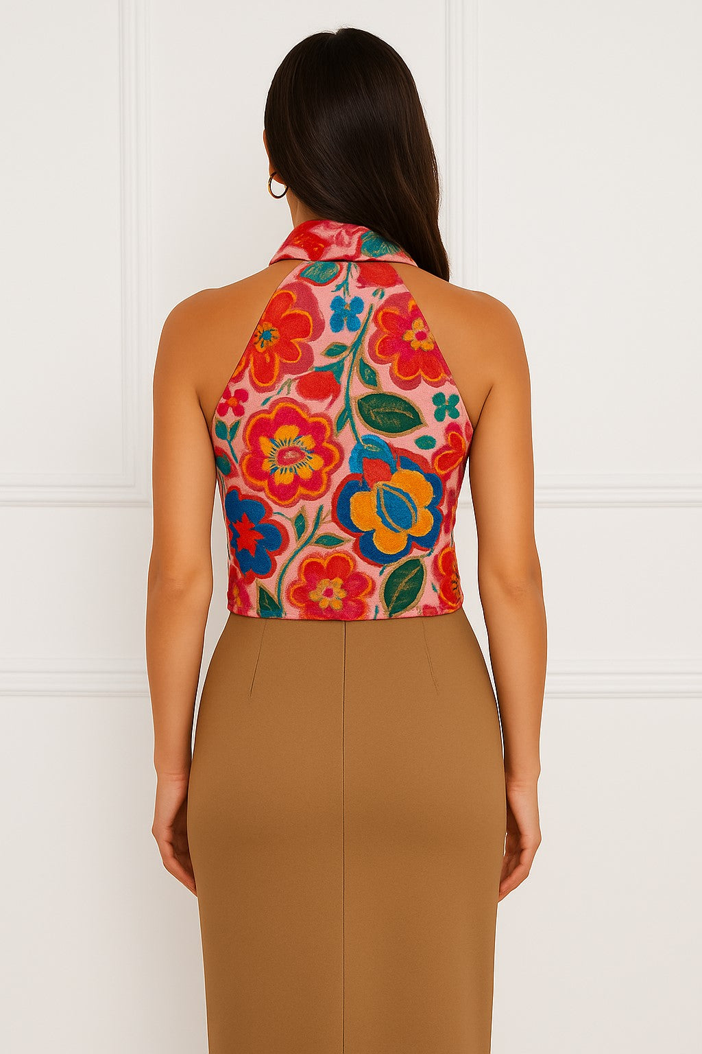 Woman wearing a colorful silk and cashmere floral halter top and cashmere pencil skirt against a white background