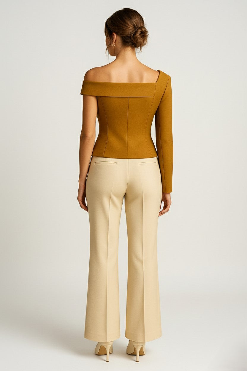 Woman wearing a asymmetrical off-shoulder cashmere top and beige pants on a white background