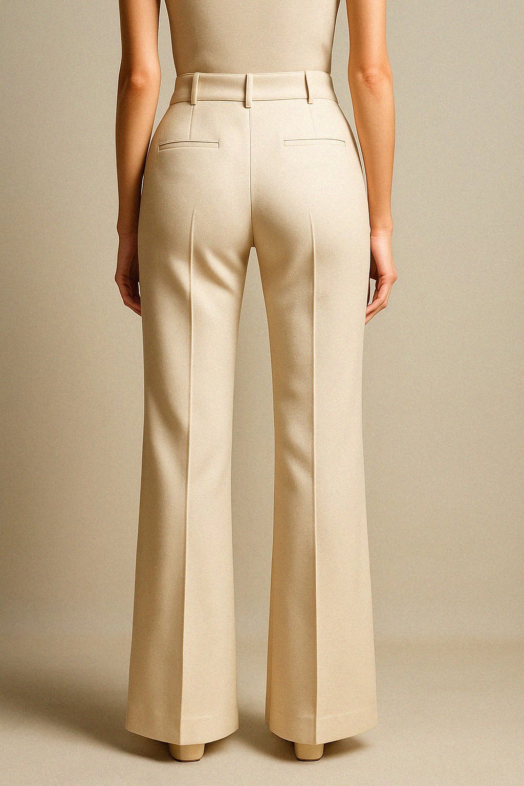 Beige wool trousers worn by a person on a beige background