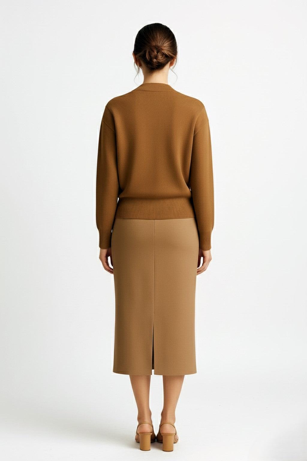 Woman wearing a cashmere cardigan and cashmere pencil skirt on a white background