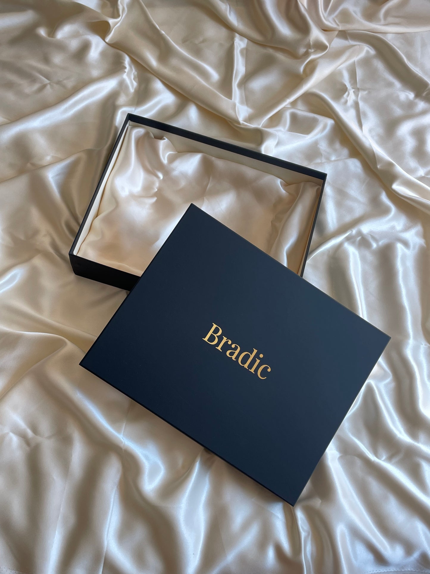 Black premium box with 'Bradic' branding on a crumpled white silk