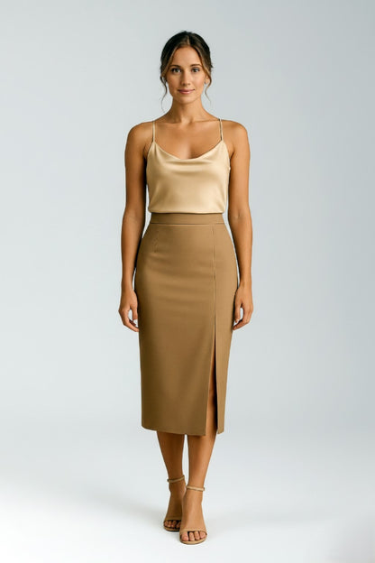 Woman wearing a silk camisole top and cashmere pencil skirt on a white background