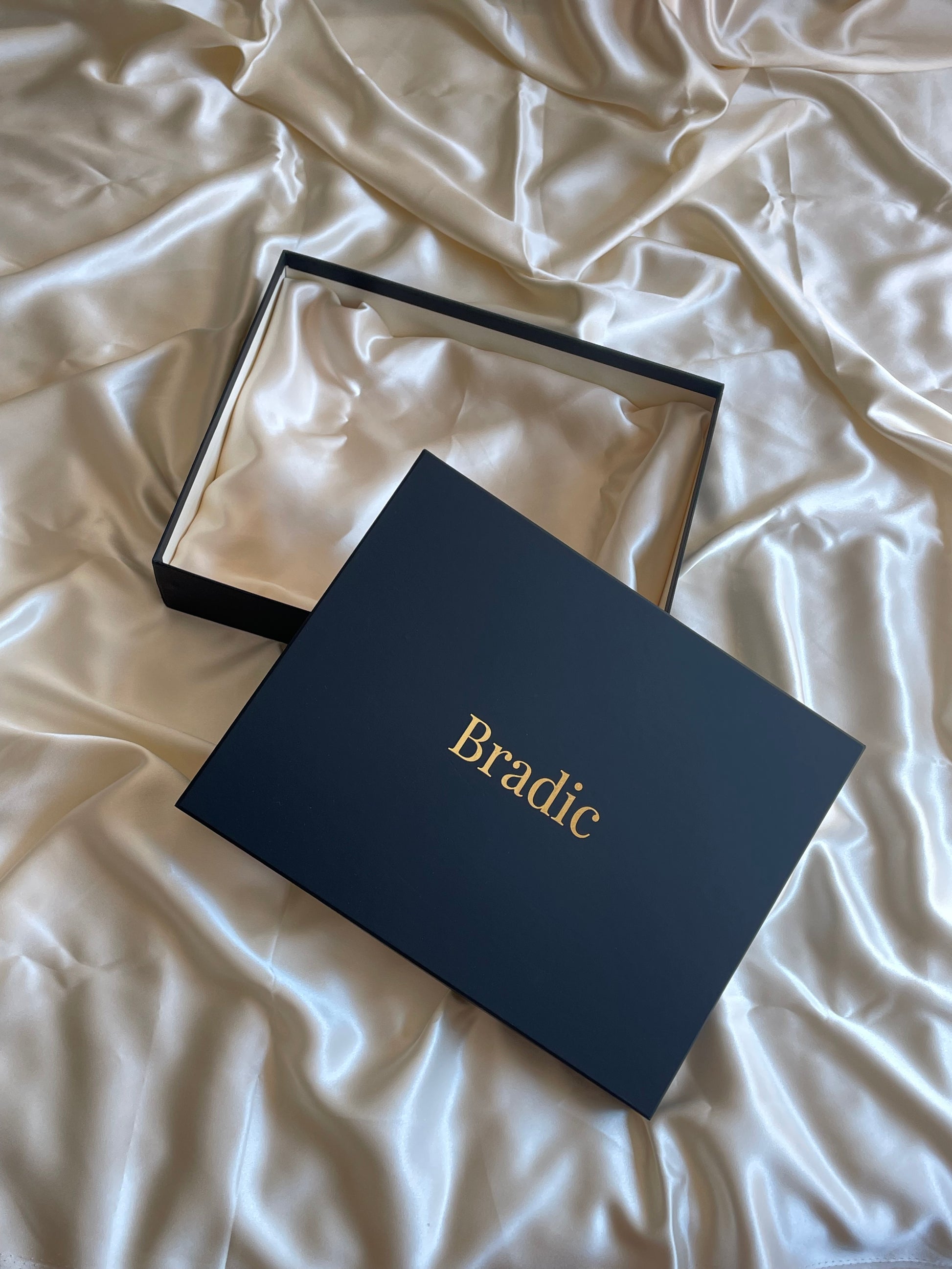 Black premium box with 'Bradic' branding on a crumpled white silk 