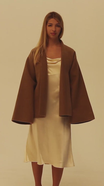 Woman wearing a 25 momme champagne silk slip dress under the double faced cashmere wrap coat.