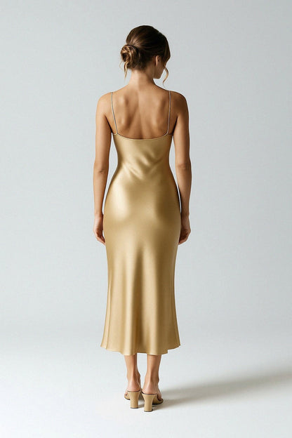 Woman wearing a silk slip dress against a plain background