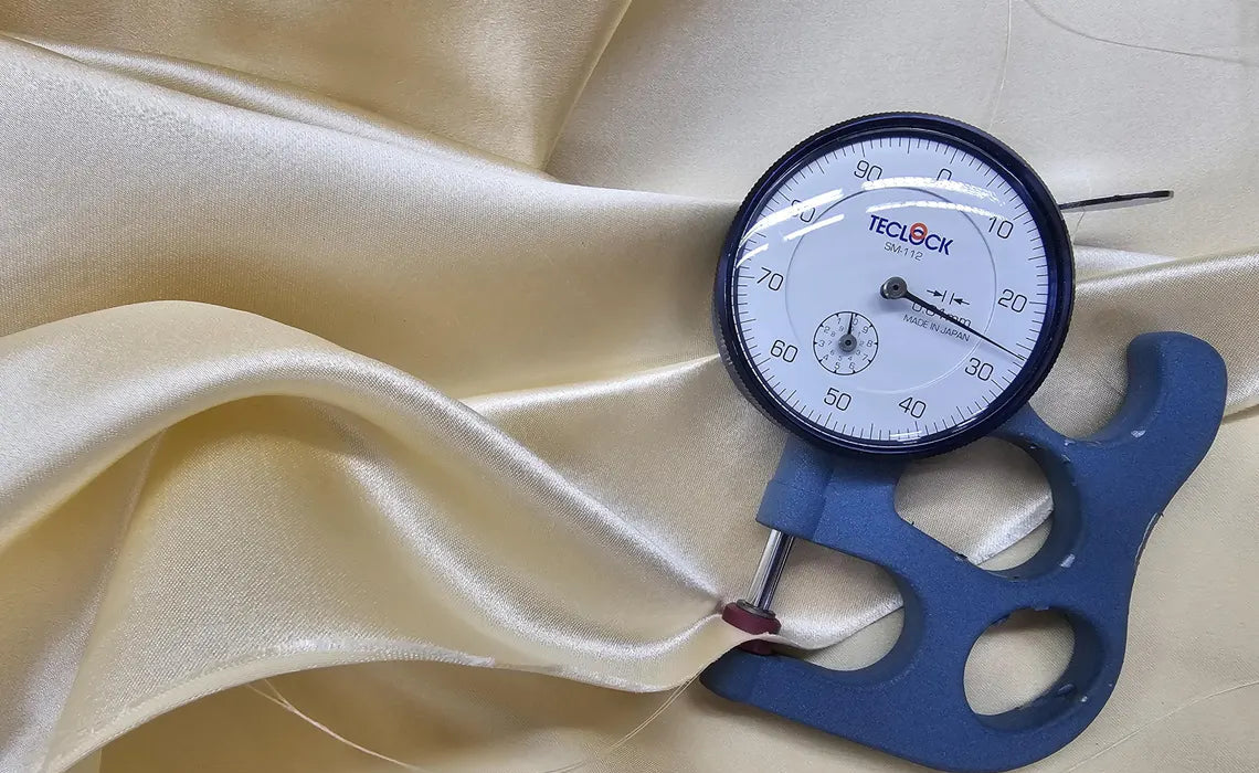 Dial indicator on a piece of fabric with a visible brand name.