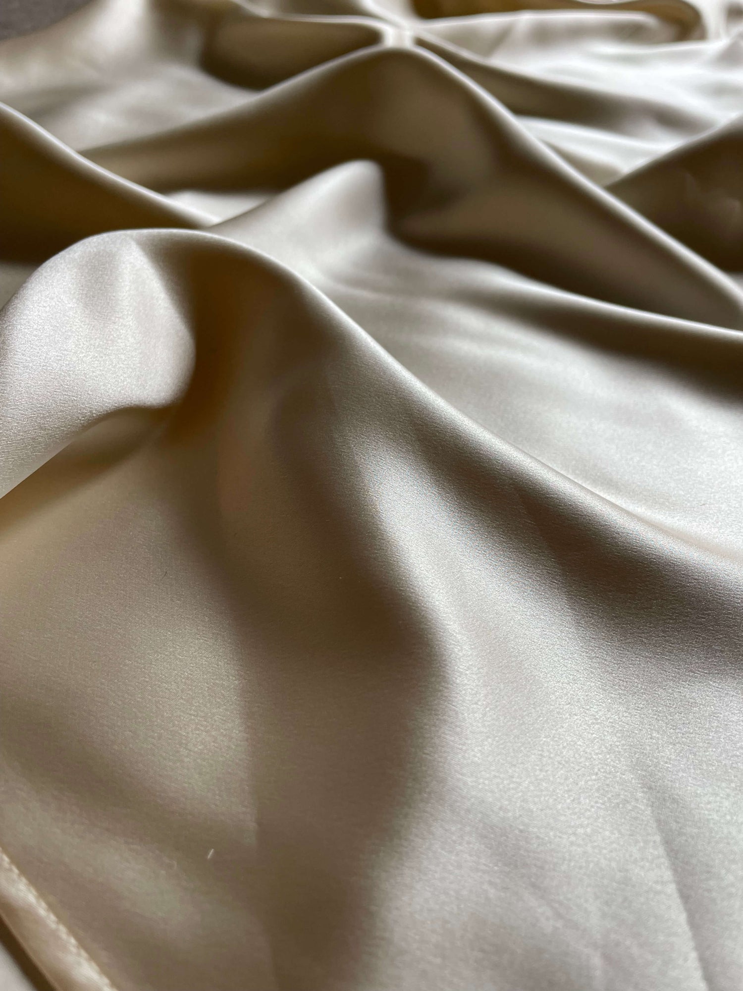 Close-up of champagne silk slip dress fabric