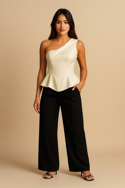 Woman wearing a white one-shoulder silk top and black pants against a beige background